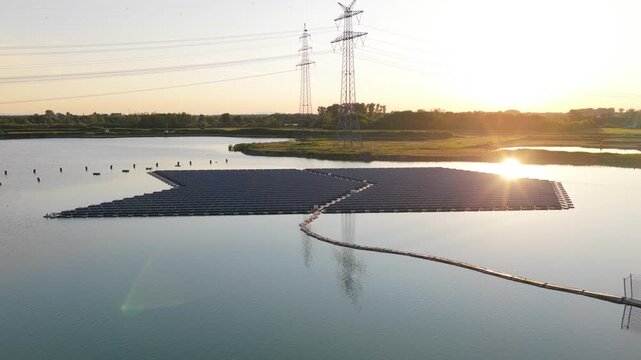 Aerial view of floating solar park by Rohr on a lake with calm water and power lines in the background in Bensheim, Hessen, Germany.