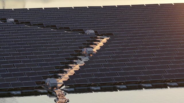 Aerial view of floating solar power plant by Rohr on water during golden hour in Bensheim, Hessen, Germany.