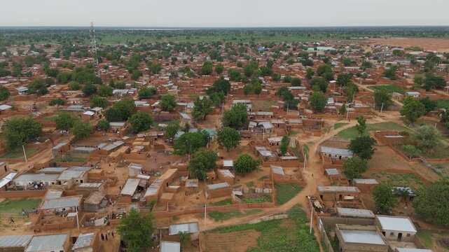 Aerial view of the Danbatta Local Government Secretariat area featuring traditional mud-brick houses, scattered trees, and dirt roads in Danbatta, Kano, Nigeria.