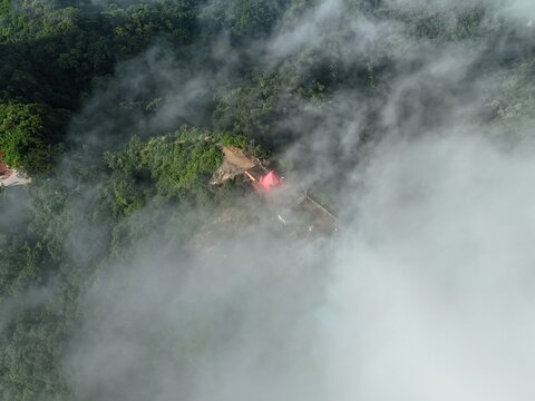 Aerial view of Chandranath Temple nestled on a lush green mountain peak surrounded by thick clouds in Sitakund, Chittagong Division, Bangladesh.
