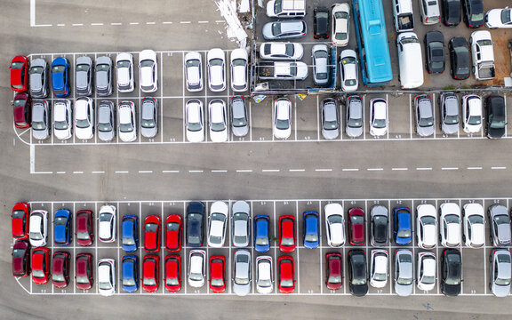 Aerial view of a car lot filled with numerous parked vehicles arranged in neat rows on asphalt in Ramat Hasharon, Tel Aviv District, Israel.