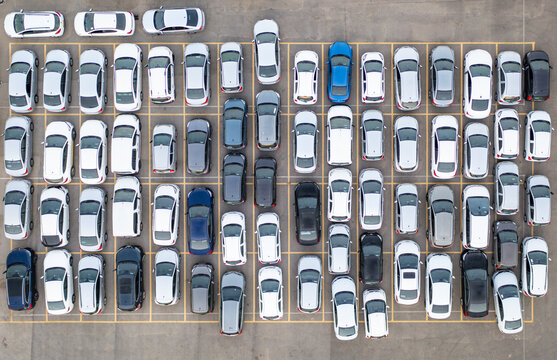 Aerial view of a car lot filled with numerous parked vehicles arranged in neat rows on asphalt, Ramat Hasharon, Tel Aviv District, Israel.