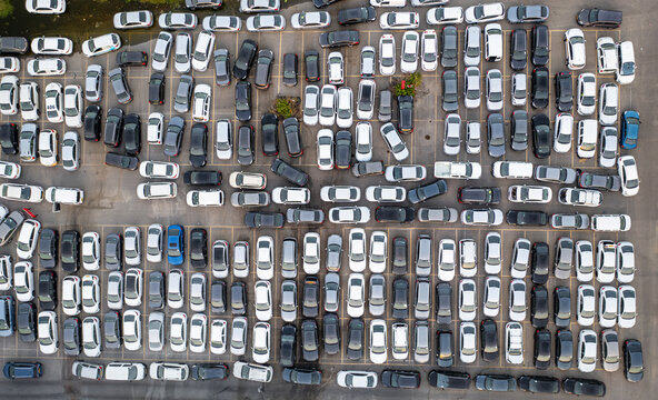 Aerial view of a car lot filled with rows of parked vehicles on an asphalt surface in Ramat Hasharon, Tel Aviv District, Israel.