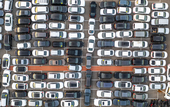 Aerial view of a car lot filled with numerous parked vehicles arranged in neat rows, showcasing a dense urban parking facility in Ramat Hasharon, Tel Aviv District, Israel.
