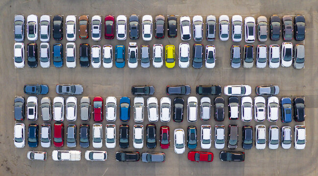 Aerial view of a car lot filled with numerous parked vehicles arranged in neat rows on an asphalt surface in Ramat Hasharon, Tel Aviv District, Israel.