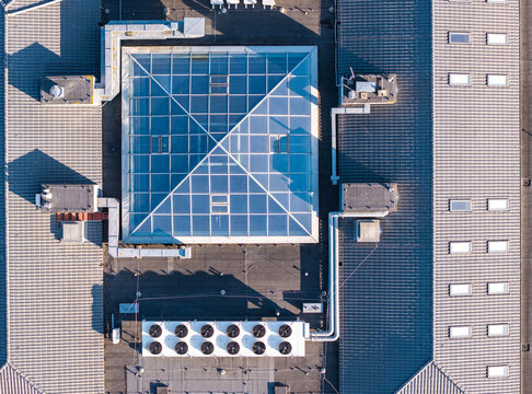 Aerial view of the Oliwa district roof featuring a large glass skylight, industrial HVAC units, and tiled roofing in Gdansk, Pomeranian Voivodeship, Poland.