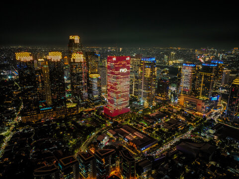Kebayoran Baru, Indonesia - 16 August 2025: Aerial view of the Sudirman Central Business District at night, featuring illuminated skyscrapers and dense urban infrastructure.