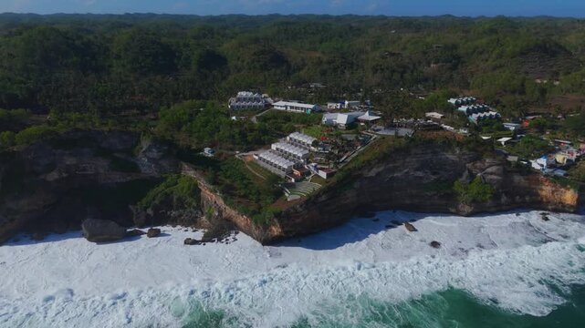 Aerial view of HeHa Ocean View resort perched on rocky cliffs overlooking the ocean waves in Kecamatan Panggang, Daerah Istimewa Yogya, Indonesia.