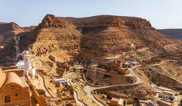 Aerial view of the historic Berber village of Chenini featuring traditional stone dwellings, winding paths, and arid landscape in Chenini, Tataouine Governorate, Tunisia.