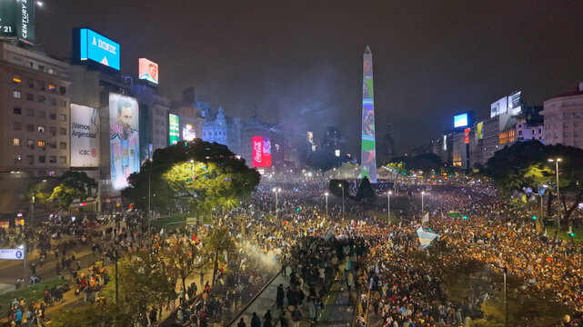 Buenos Aires, CABA, Argentina - 19 July 2026: Aerial view of the massive crowd celebrating at the Obelisco de Buenos Aires on Avenida 9 de Julio at night, with bright city lights.