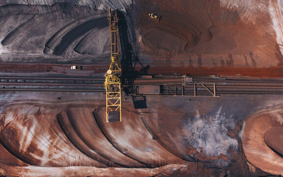 Aerial view of Tata Steel industrial site with heavy machinery, raw material piles, and railway tracks in Velsen-Noord, Noord-Holland, Netherlands.