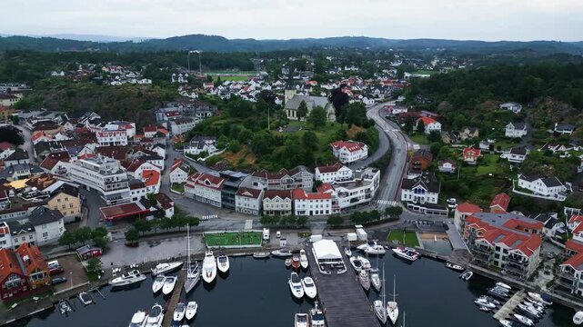 Aerial view of the harbour with boats moored at the docks and surrounding town buildings in Grimstad, Agder, Norway.