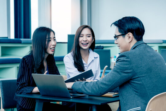A group of Gen Z Asian business consulting, exchanging information in offices, co-working spaces.