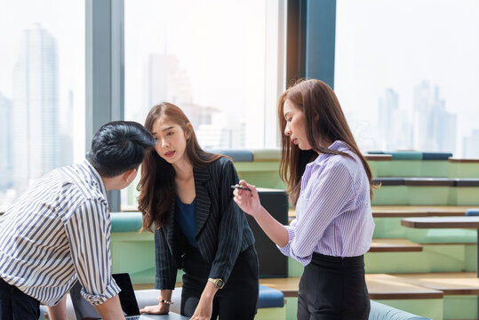 A group of Gen Z Asian business consulting, exchanging information in offices, co-working spaces.