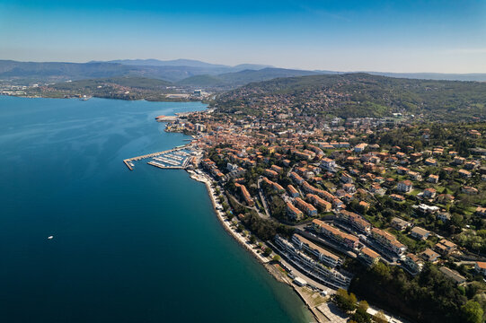Aerial view of Muggia with its marina, historic buildings, and coastal landscape along the Adriatic Sea in Trieste, Friuli-Venezia Giulia, Italy.