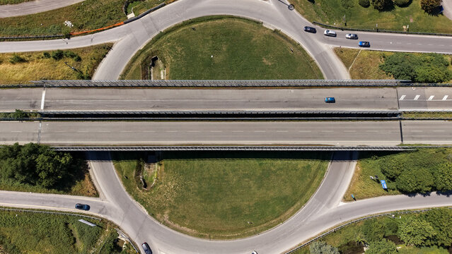 Aerial view of a highway interchange with modern road infrastructure and transportation networks in the suburbs of Milan, Lombardy, Italy.
