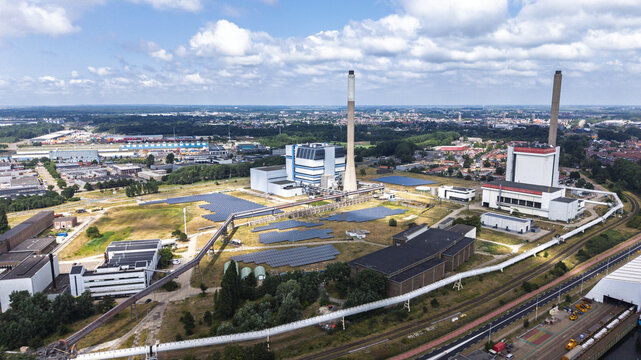 Aerial view of the Tata Steel industrial complex with large chimneys, factory buildings, and solar panels in the urban landscape of Velsen-Noord, Noord-Holland, Netherlands.