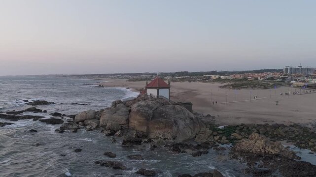 Aerial view of the historic Senhor da Pedra chapel perched on a rocky outcrop at the beach in Vila Nova de Gaia, Porto, Portugal.