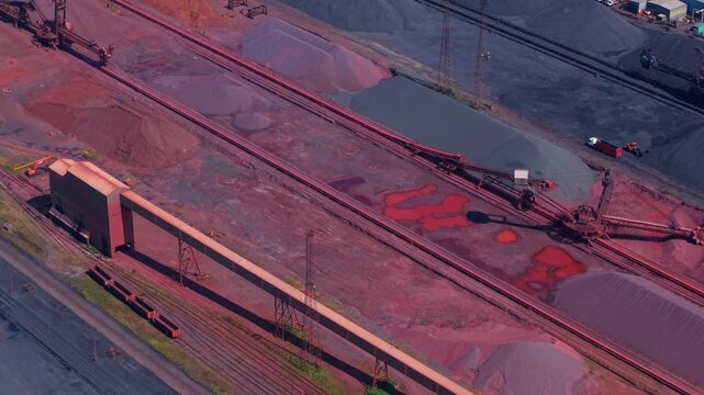 Aerial view of Immingham Bulk Terminal featuring large stockpiles of raw materials, industrial conveyor systems, and heavy machinery in South Killingholme, England, United Kingdom.