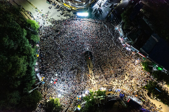 Chattogram, Bangladesh - 20 July 2026: Aerial view of a massive crowd of people gathered in the city square at night, illuminated by bright street lights and surrounding urban buildings.