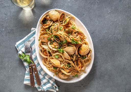 Seafood Italian Pasta. Spaghetti with vongole. Clams spaghetti on white plate with white wine