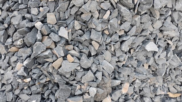 A top-down, close-up view of a dense pile of grey crushed gravel and aggregate stones used for construction and landscaping.