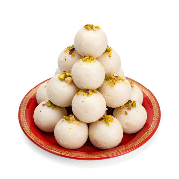 Stack of white coconut laddoo sweets on a red plate isolated on transparent background