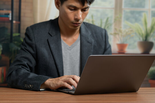 Young Professional Man Using Laptop for Work or Study in Modern Office