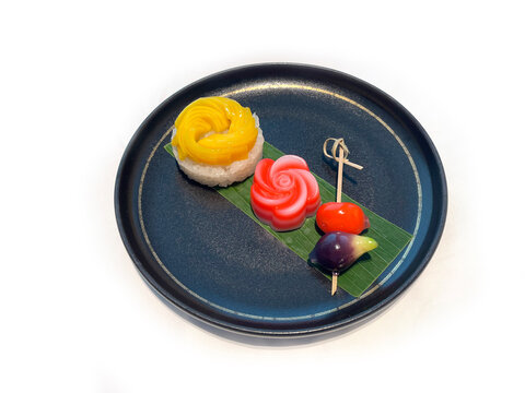 Thai Dessert Platter. A delightful assortment featuring sweet mango sticky rice, chewy layered jelly (Khanom Chan), and glossy, mung bean marzipan fruits (Luk Chup)