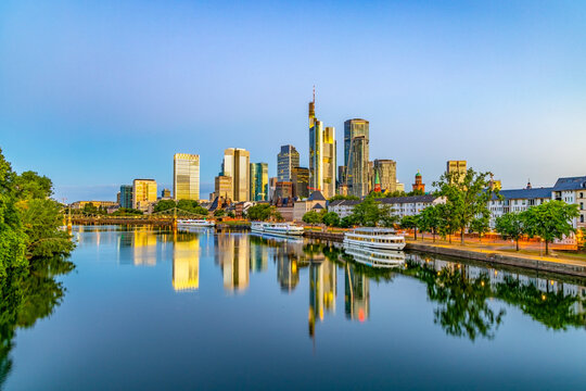 scenic skyline of Frankfurt am Main in early morning light and reflection in river Main