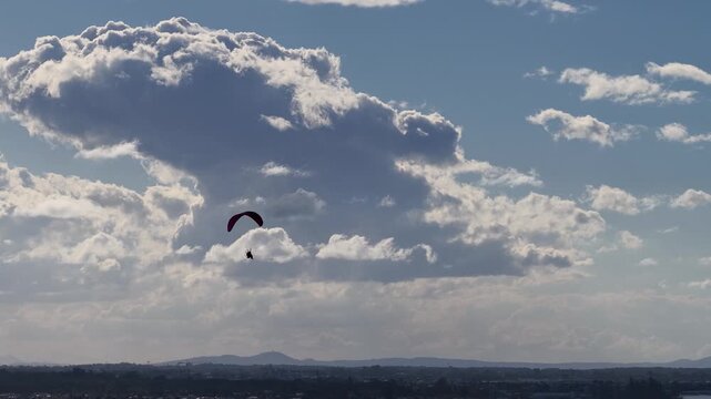 Paramotor Pilot Flying Over Surfers Paradise with Large Clouds