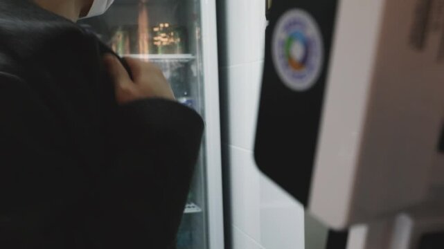 식당 매장에서 직원이 키오스크 기기를 꼼꼼히 점검하는 모습