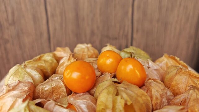 Cape gooseberry on wooden plate. 