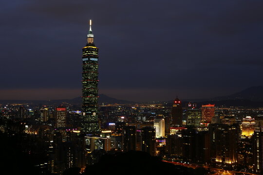 Taipei 101 tower stands tall against the night cityscape.