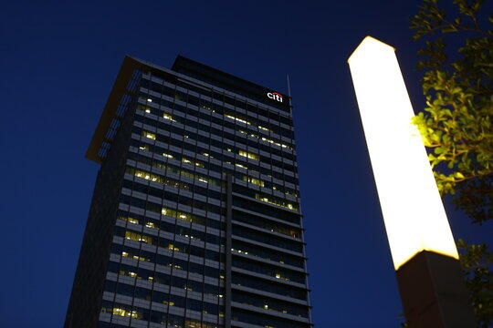 A modern bank building stands under the dark blue night sky.