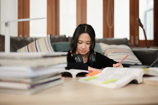 One Asian teenage girl concentrates on learning at home, reading textbooks, note writing, self-tutorial exams, preparation for back to school, Homeschooling, university knowledge education lifestyle.