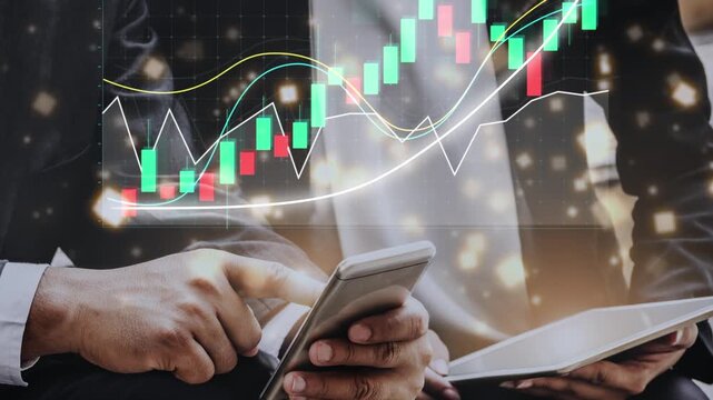 A business professional examines stock market trends using a smartphone and tablet in a modern office. Graphical data overlays enhance the financial analysis process. Copula