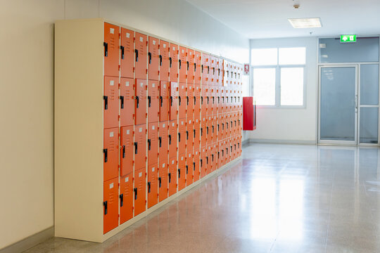 Row of metal lockers in school or office hallway corridor interior, Empty hallway with lockers and shiny floor in modern building interior, Student lockers cabinet row in clean school