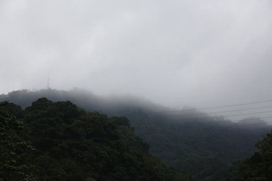 Misty mountains stand under a cloudy sky.