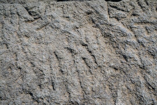 Close-up view of ancient andesite stone block wall texture on a historical temple structure.