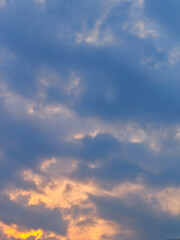 Obraz premium Warm orange and gold light illuminates layered cumulus clouds against a deep blue evening sky at dusk. Ideal for travel blogs, wellness brands, and motivational design projects seeking a serene, hopef