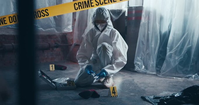 Forensic specialist places an evidence number and measuring scale beside a woman&rsquo;s shoe at a crime scene.