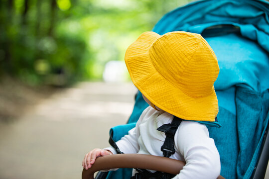 Curious Baby Pointing While Sitting in a Stroller Outdoors