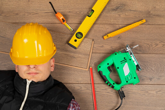 Tired Construction Worker Resting Among Flooring Installation Tools