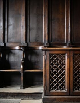 Cinematic photography of a dark wooden confessional screen in an empty catholic church copy space