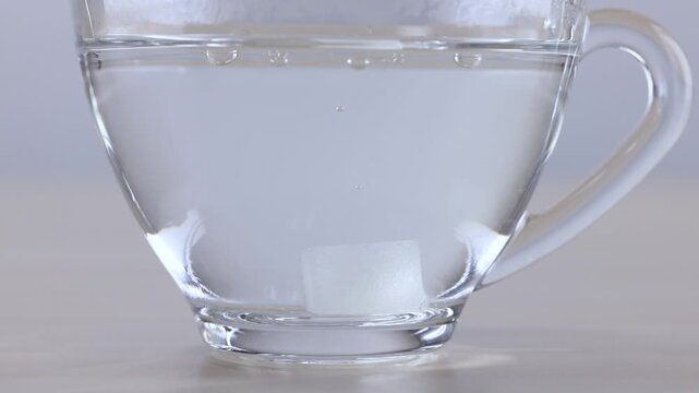 Sugar Cube Dissolving in a Glass Cup of Water
