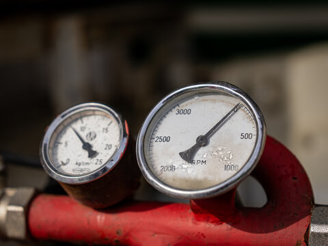 Close-up of pressure and RPM gauges on vintage firefighting equipment.