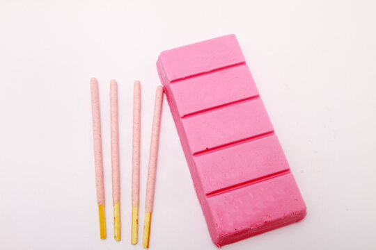 pink chocolate bar and pink stick on white table