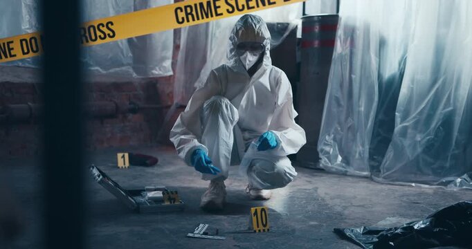 Forensic investigator examines a cartridge case found at a crime scene near a numbered evidence marker.