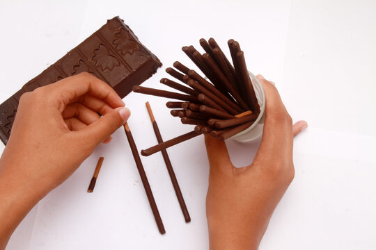 hands holding a glass of chocolate stick